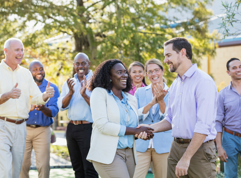 Employee Being Recognized as Coworkers Clap